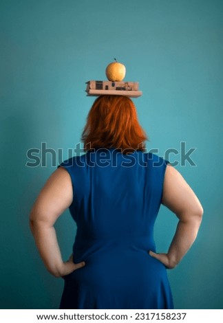  a woman holds a book on her head, an apple on a book