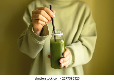 A woman holds a bottle of freshly squeezed vegetable or fruit juice in her hands. The concept of a healthy lifestyle, a healthy body - Shutterstock ID 2177598323