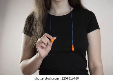 Woman Holds Bright Earplugs. Closeup.