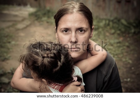 A woman holds a child, trying to calm him down. The child is three years.
