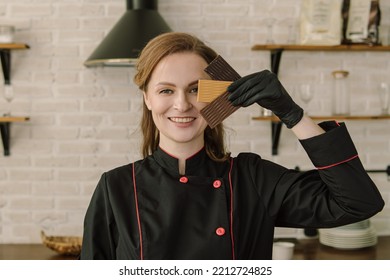 Woman Holds Chocolate Bars. Soft Focus. Professional Chocolatier In The Kitchen