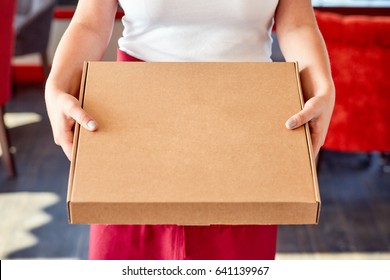 Woman Holds Closed Box With Pizza