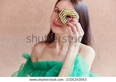 Woman holds colorful doughnut. Vibrant summer photography. Creative National Doughnuts Day concept