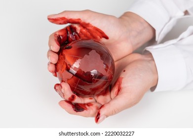 A Woman Holds A Crystal Globe Smeared In Blood On A White Background.