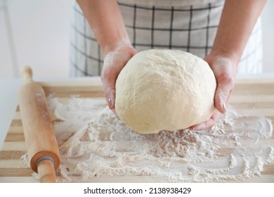 Woman holds dough in her hands and shows at camera. Increasing price of wheat, flour and bread. Homemade bread preparation. Economic crisis.