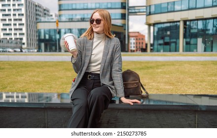 Woman holds a eco paper cup with coffee or tea and walks in spring park. Drink coffee time. Disposable paper cup. Take away. Hot beverage. Blank space.  - Powered by Shutterstock