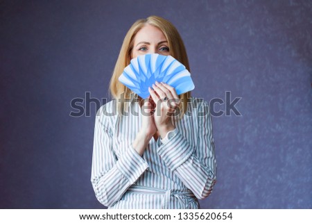 Woman holds fan of cards