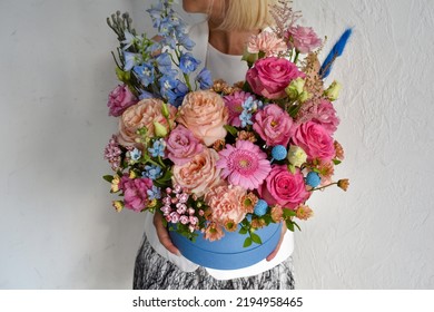 A Woman Holds Flowers In A Box In Her Hands. Photo For The Flower Catalog Of A Flower Shop. Fresh Fresh Flowers As A Gift