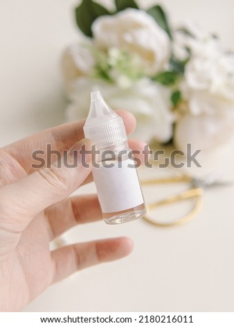 Woman holds fragrance for candles and soap in a plastic bottle. Natural. Floral aroma. Liquid for electronic cigarettes and vaping