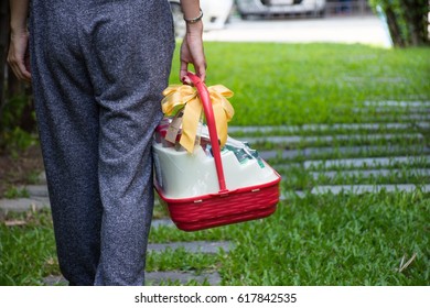 Woman Holds A Gift Basket To Congratulate Her Friends.