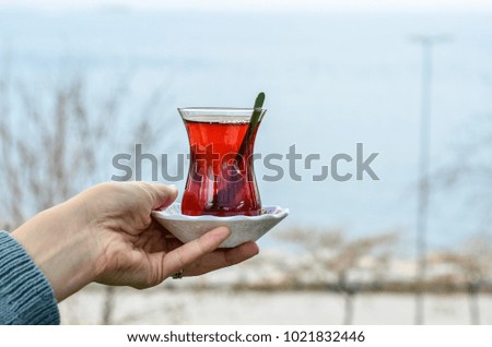 Woman holds  a glass of Turkish tea