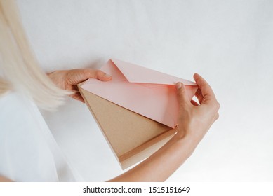 Woman Holds In Hand Paper Envelope And Box. New Mail, Message. Postal Service. Young Girl Want Send Or Receive Letter And Package. Blank Envelope, Empty Space. People Communication. Envelope Closeup