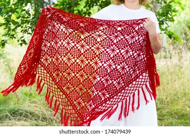Woman holds in hands knitted shawl