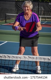 Woman Holds Her Pickleball Paddle Ready For A Volley