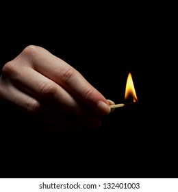 Woman Holds A Match / Matchstick On Fire. A Light In The Dark.