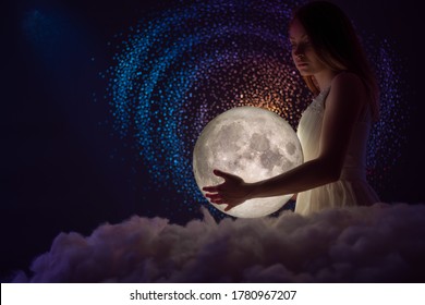 The woman holds the moon in her hands, tender photography, female magic. Against the background of stars - Shutterstock ID 1780967207