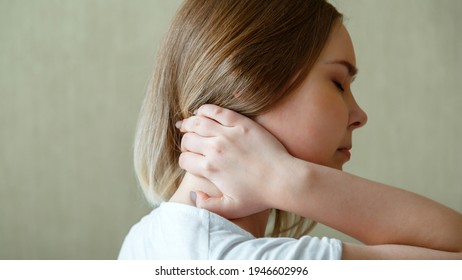 Woman holds neck with pain cervical muscle spasm by hand. Neck pain, cervical vertebrae, Disease of musculoskeletal system in young woman. Long web banner.