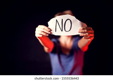 Woman holds paper with message to help her in front of black background. People, family violence, crime concept - Shutterstock ID 1555536443
