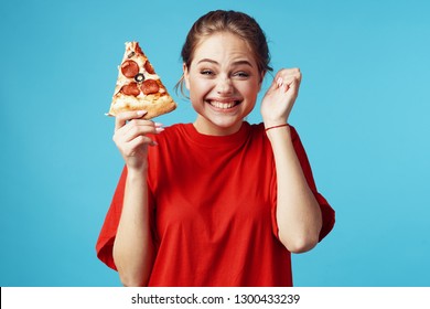 A woman holds a pizza with salami sausage and laughs gesticulating with her hands