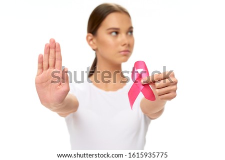 A woman holds a ribbon in her hands a charity health care fund