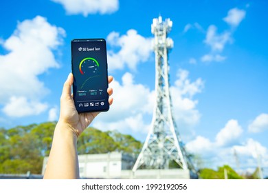 Woman Holds Smartphone With 5g Speed Test Near Base Station