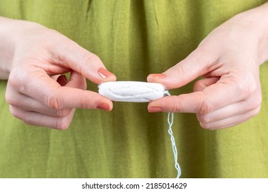 A Woman Holds A Tampon In Her Hand.