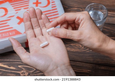 A Woman Holds Two White Pills