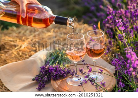 A woman holds wine in glasses. Picnic in the lavender field. Selective focus. nature.