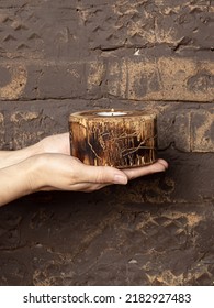 Woman Holds Wooden Round Candle Holder On Dark Wall Background. Natural Wood Texture