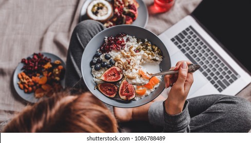 Woman In Home Clothes Eating Vegan Rice Coconut Porridge With Figs, Berries, Nuts. Healthy Breakfast Ingredients. Clean Eating, Vegan Food Concept