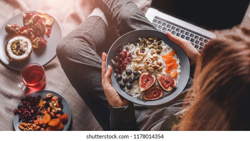 Woman In Home Clothes Eating Vegan Rice Coconut Porridge With Figs, Berries, Nuts. Healthy Breakfast Ingredients. Clean Eating, Vegan Food Concept