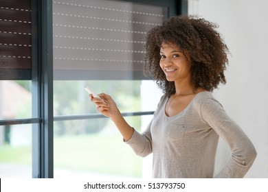Woman at home controlling shutter opening