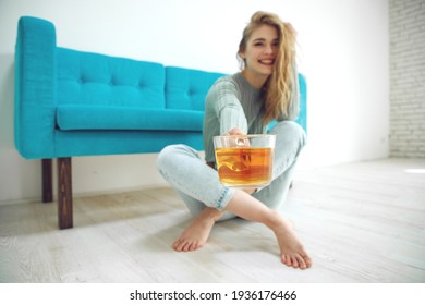 A Woman At Home Is Drinking Tea On The Couch. High Quality Photo.