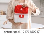 Woman with home first aid kits in kitchen, closeup
