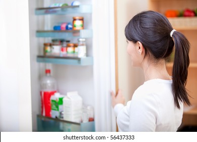 Woman at home looking inside the fridge