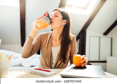 Woman In Home Office Drinking Orange Flavored Amino Acid Vitamin Powder.Keto Supplement.After Exercise Liquid Meal.Weight Loss Fitness Nutrition Diet.Immune System Support.Organic Citrus Fruit