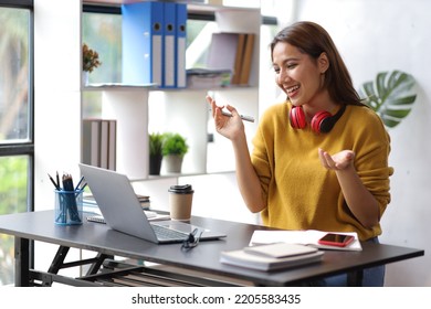 Woman in a home office is working on a laptop in an online conference and chatting with a colleague over a video call. - Shutterstock ID 2205583435