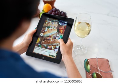 Woman At Home Relaxing Ordering Food Online Delivery Takeout App On Digital Tablet Device