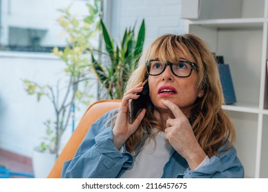 Woman At Home Talking On Mobile Or Cell Phone Doubting Pensive