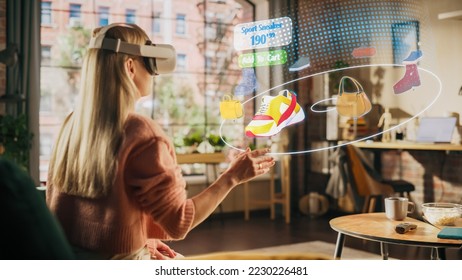 Woman at Home, Using Virtual Reality Headset for Online Shopping, Browsing through Pictures of Stylish Brand Shoes and Handbags. Scrolling Mock-up Internet Clothing Store App for e-Commerce products - Shutterstock ID 2230226481