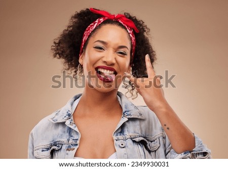 Woman, horns sign and studio portrait with tongue, comic smile and funny face with beauty by brown background. African girl, model or student with icon, crazy and rock star hand with laugh for beauty