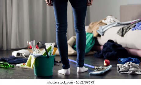 Woman horrified by mess left after party in her apartment, cleaning service - Shutterstock ID 1052789693