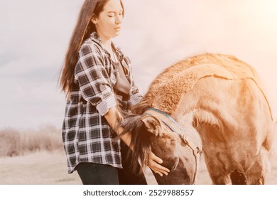 Woman Horse Field - Young woman gently petting a brown horse in an open field on a sunny day. - Powered by Shutterstock