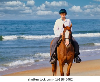 A Woman Horseback Riding At The Beach