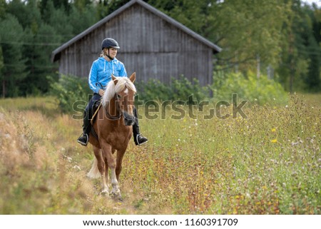 Woman horseback riding on country