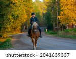 Woman horseback riding on the road