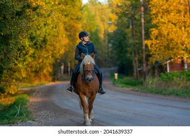 Woman Horseback Riding On The Road