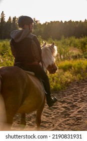 Woman Horseback Riding In Sunset 