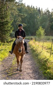 Woman Horseback Riding In Sunset