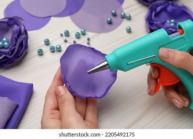 Woman With Hot Glue Gun Making Craft At Wooden Table, Closeup